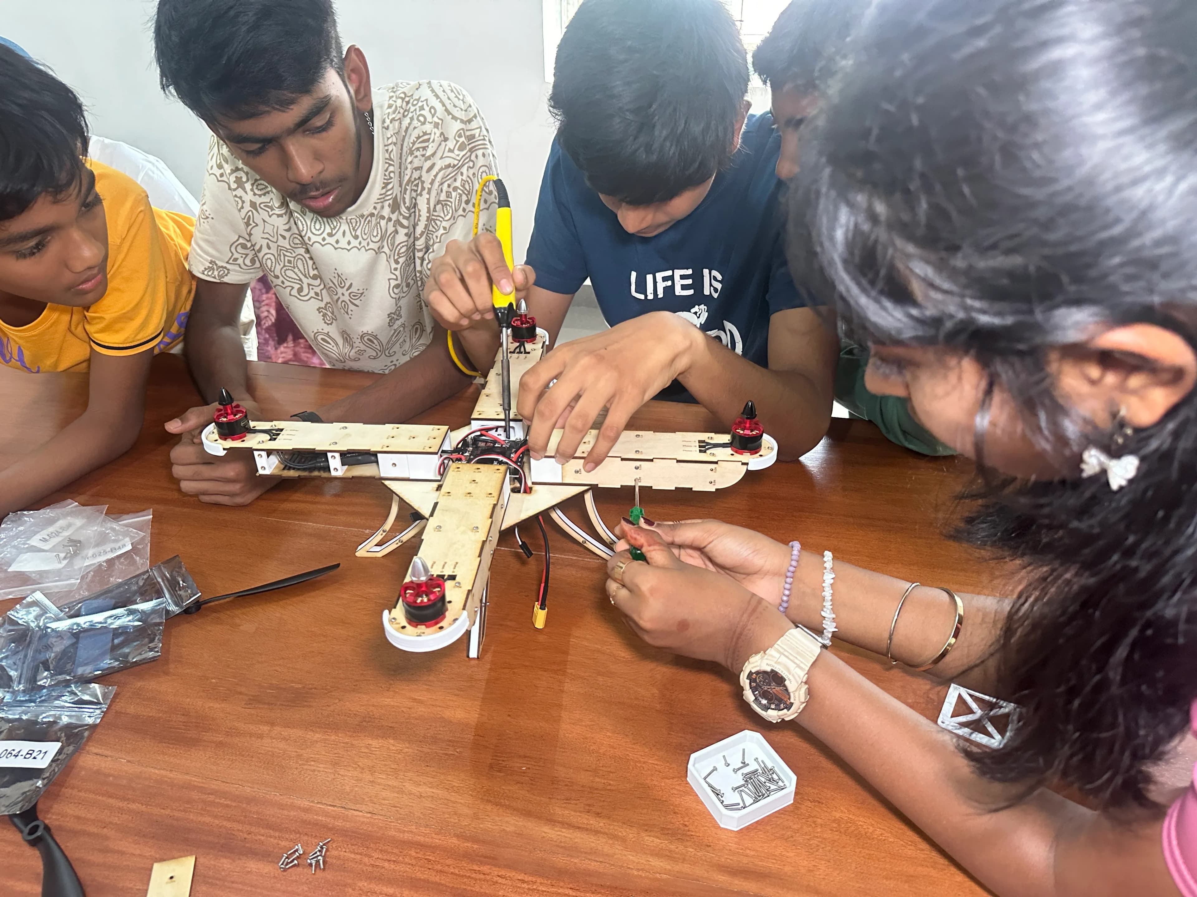 Student team assembling a quadcopter drone at a competition booth